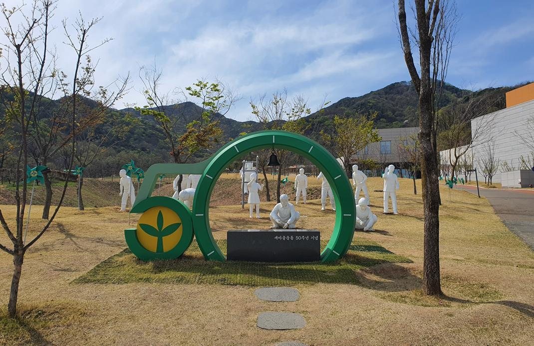 야외 조각상 — 흰 인물 조각들과 초록 원형 조형물